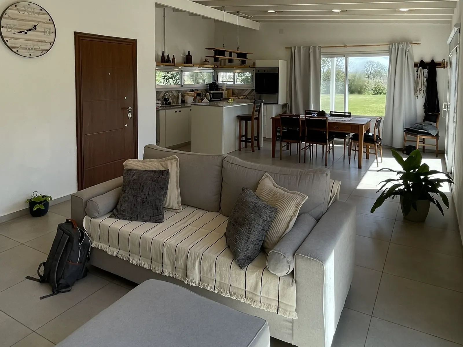 Living con ventanales a la pileta en la casa quinta en Lobos